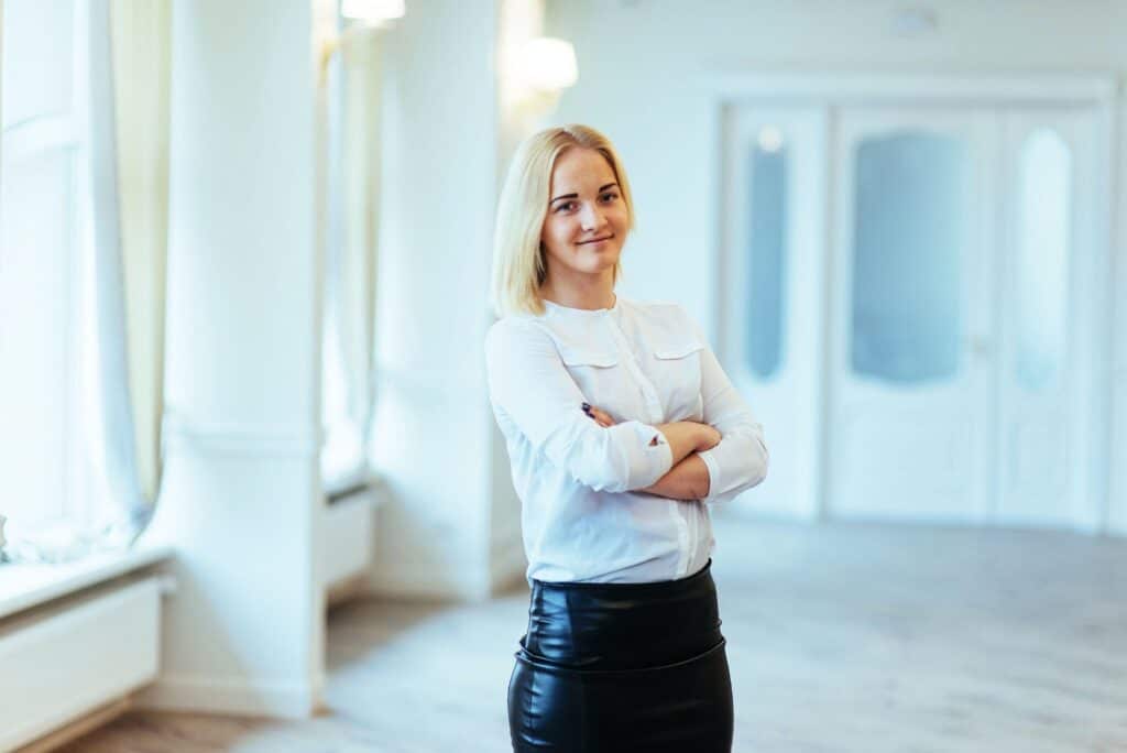 Happy business woman looking confident with modern building as b